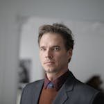 Portrait of a businessman in a formal suit in an indoor setting.
